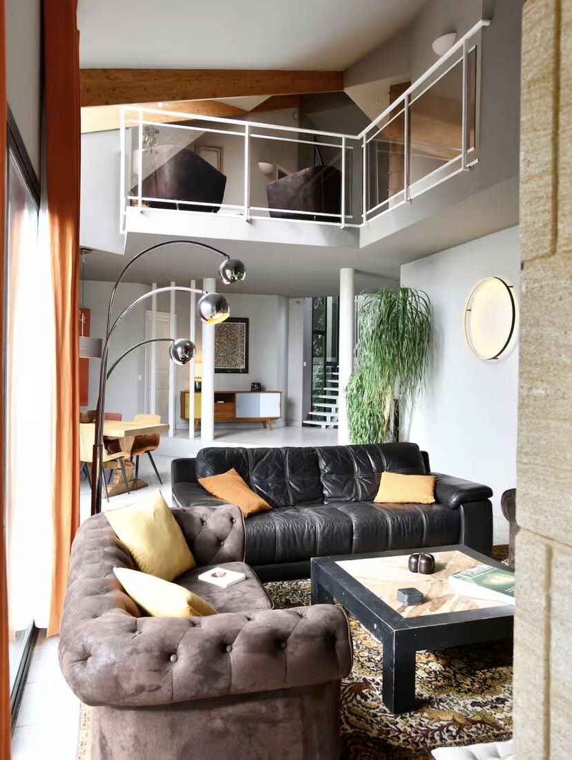 Séjour en duplex avec canapés Chesterfield et mezzanine
