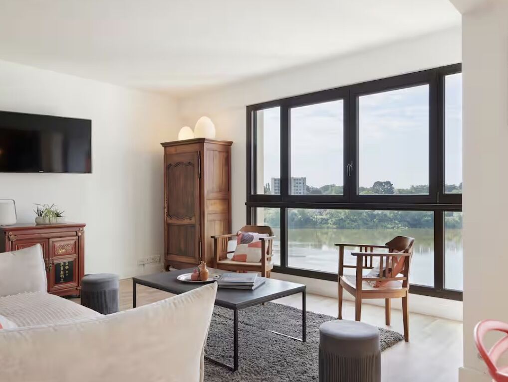 Salon lumineux avec grande baie vitrée donnant sur la Loire