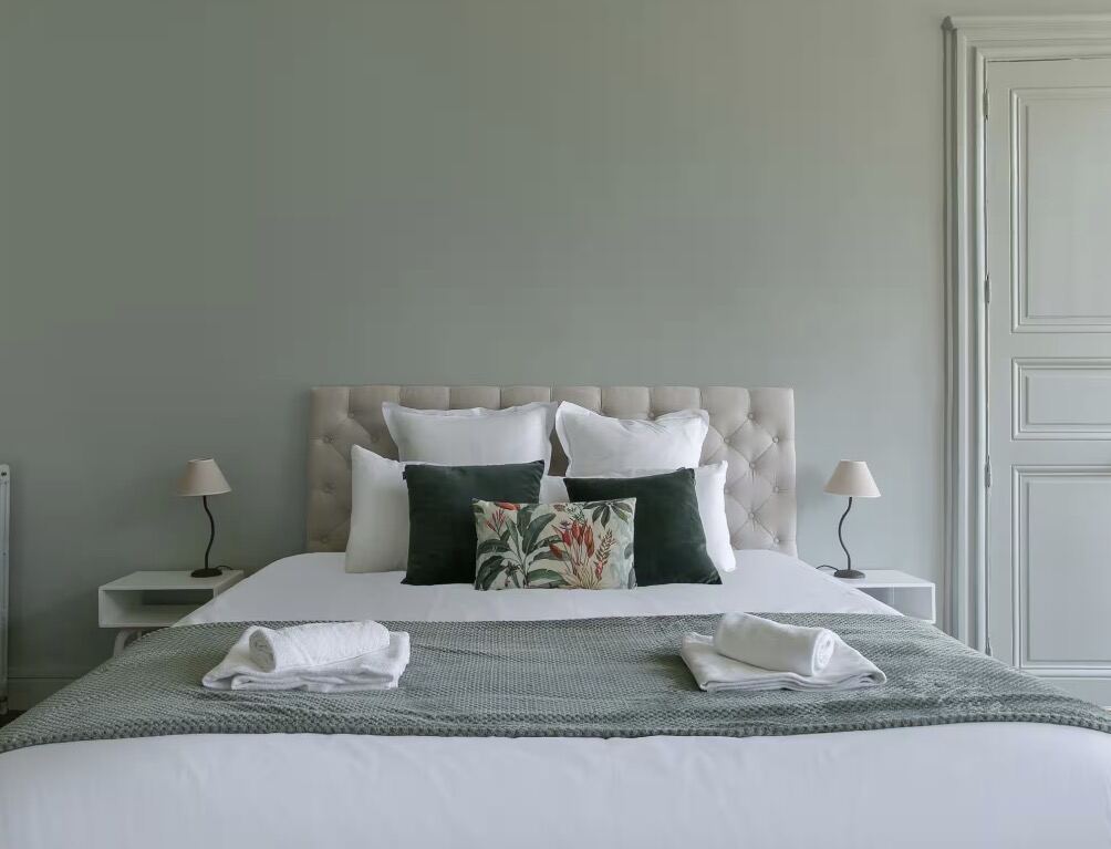 Chambre aux tons verts avec tête de lit capitonnée