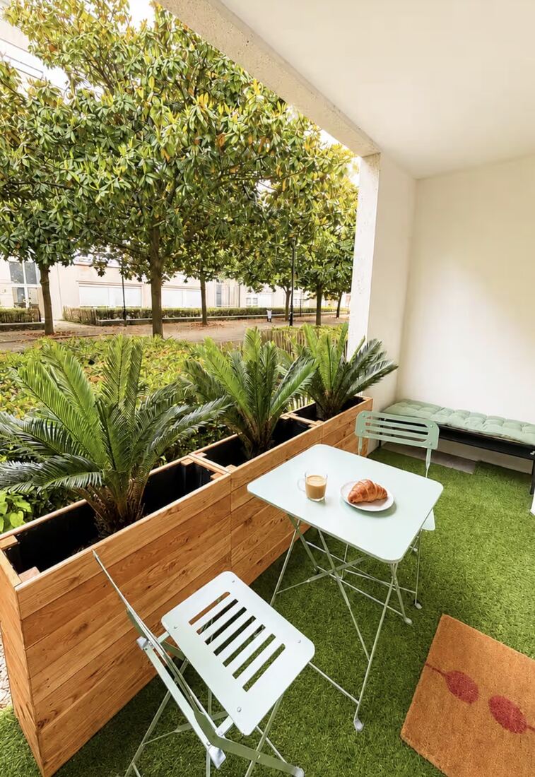 Terrasse avec bacs de palmiers et table de jardin