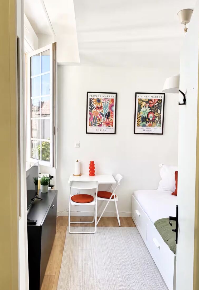 Studio lumineux avec coin bureau et affiches colorées